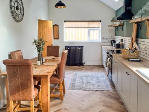 a kitchen with a wooden table and a dining room at Normandy in Wyberton
