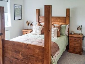 a bedroom with a wooden bed with a wooden frame at Normandy in Wyberton