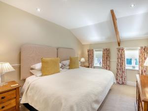 a bedroom with a large bed and two windows at Shellrigg - Uk49891 in Preston +10 photos