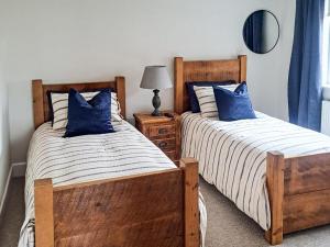 two beds with blue pillows in a bedroom at Normandy in Wyberton +9 photos