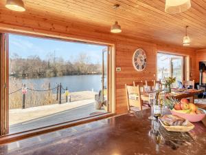 a dining room with a large window and a view of a lake at Malibu Lakehouse in Pentney