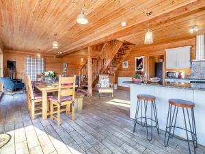 a kitchen and living room with a wooden ceiling at Malibu Lakehouse in Pentney +26 photos