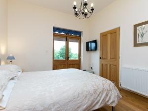 a bedroom with a large white bed and a window at Parkers Lodge in Mathon