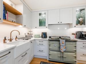 a kitchen with white cabinets and a sink at Mousehall Oast in Wadhurst +16 photos