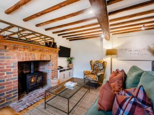 a living room with a couch and a fireplace at Mousehall Oast in Wadhurst
