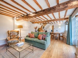 a living room with a green couch and a table at Mousehall Oast in Wadhurst