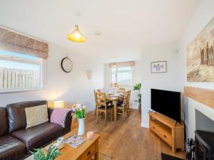 a living room with a couch and a table at Swyn Y Don in Llanfair