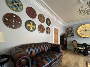 a living room with a couch and plates on the wall at Clan Young Suite in Berwick-Upon-Tweed