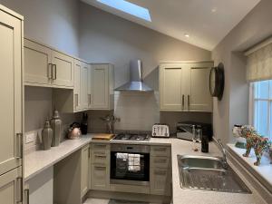 a kitchen with white cabinets and a sink at Clan Young Suite in Berwick-Upon-Tweed