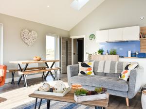 a living room with a couch and a table at Drums Beach House in Foveran