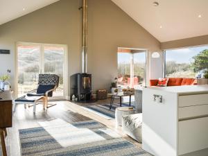 a kitchen with a living room with a stove at Drums Beach House in Foveran +18 photos