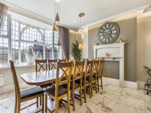 a dining room with a table and chairs and a clock at No3 On The Severn in Bridgnorth