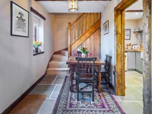 a dining room with a table and chairs on a rug at Rustic Retreat in Llangadog