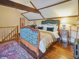 a bedroom with a large bed and a staircase at Rustic Retreat in Llangadog