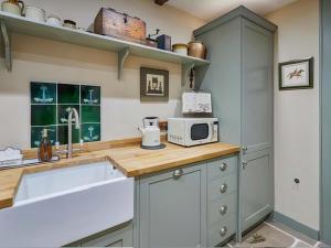 a kitchen with a counter top with a microwave at Rustic Retreat in Llangadog