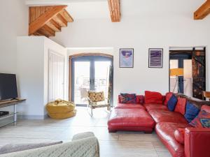 a living room with a red couch and a tv at The Cart Arms in Gloucester