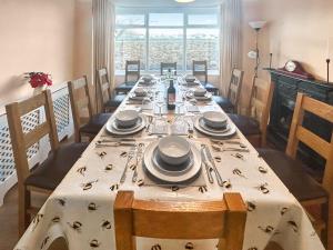 a dining room with a table with plates and utensils at Hill View in Minehead