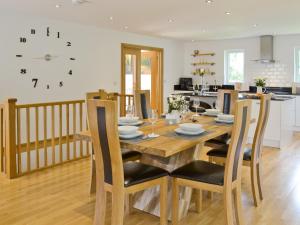 a kitchen and dining room with a wooden table and chairs at Florina in Cheriton Bishop