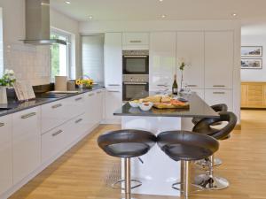 a kitchen with white cabinets and a table with food on it at Florina in Cheriton Bishop