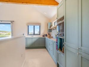 a kitchen with blue cabinets and a window at The Old Cowshed in Porchfield