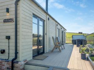 a house with a deck with a sliding glass door at The Old Cowshed in Porchfield