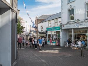 a group of people walking down a street with shops at The Old Cowshed in Porchfield