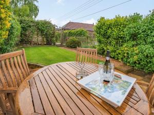 a wooden table with glasses and a bottle of wine at Stonegarth in Snitterby