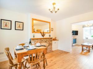 a dining room with a table and chairs and a fireplace at Stonegarth in Snitterby +15 photos