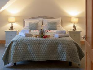 a bedroom with a large bed with two night stands at Drumlanrig Mains Cottage - Uk7174 in Carronbridge