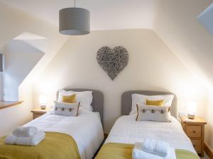 two beds in a room with a heart on the wall at Drumlanrig Mains Cottage - Uk7174 in Carronbridge +14 photos
