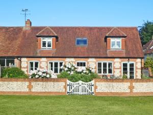 a large brick house with a white fence at The Owl House in Bishops Waltham