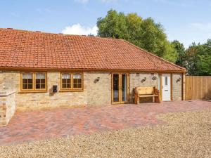 a brick house with a bench in front of it at Tawny Acre Barn - Uk38614 in Wisbech