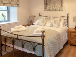 a bedroom with a large bed with a wooden floor at Slatehouse Cottage - Uk7562 in Carronbridge +13 photos