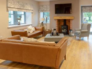 a living room with two couches and a fireplace at Slatehouse Cottage - Uk7562 in Carronbridge