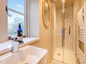 a bathroom with a sink and a shower at The Ostlers Cottage in Sleaford +5 photos