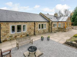 a stone house with a barbecue in front of it at Cunliffe Cottage in Hathersage
