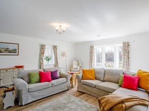 a living room with two couches and colorful pillows at Cunliffe Cottage in Hathersage