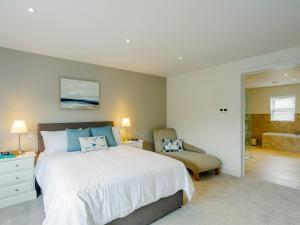 a bedroom with a large bed and a chair at Cunliffe Cottage in Hathersage