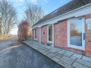 a brick building with a window on a street at One Chainbridge Barns in Skegness