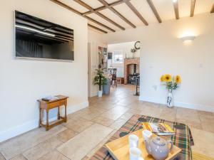 a living room with a table and a tv at One Chainbridge Barns in Skegness +18 photos