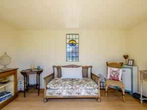 a bedroom with a bed and a window and a chair at Holly Lodge in Hemsby