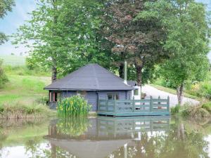 a small blue house in the middle of a pond at Mallard Roundhouse - Uk33891 in Cullompton