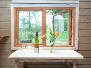 a bottle of wine and glasses on a window sill at Mallard Roundhouse - Uk33891 in Cullompton