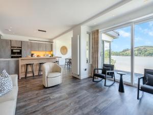 an open kitchen and living room with a view of the water at Berkeley in Kippford