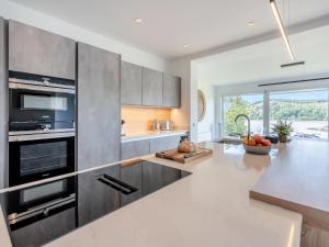 a kitchen with stainless steel appliances and a table at Berkeley in Kippford +20 photos