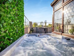 a jacuzzi tub in front of a green wall at Clay Lake Cottages - Dad's Shed in Covenham