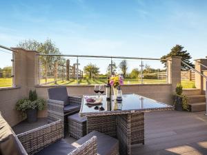 a patio with a table and chairs on a balcony at Clay Lake Cottages - Dad's Shed in Covenham
