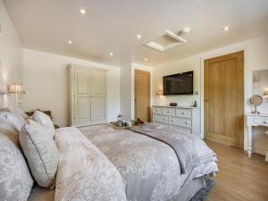 a bedroom with a large bed and a television at Clay Lake Cottages - Dad's Shed in Covenham +12 photos