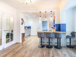 a kitchen with a bar and two stools at The Gables in Bridlington
