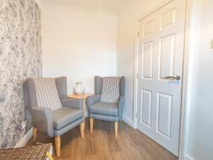 two chairs and a table in a room with a door at The Gables in Bridlington